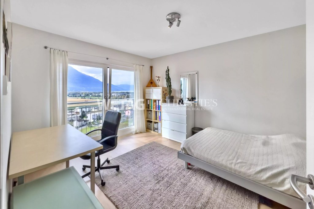 Helles Schlafzimmer mit Arbeitsbereich und Bergblick