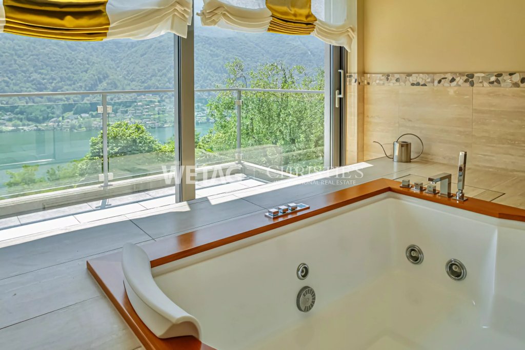Luxuriöses Badezimmer mit Whirlpool und Seeblick