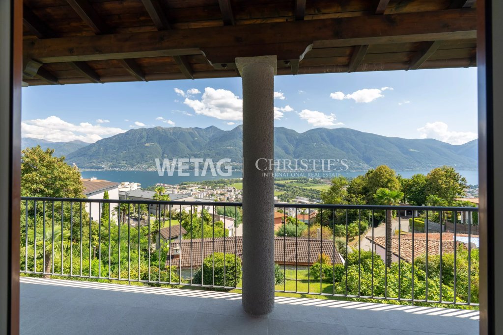 Überdachte Terrasse mit Panoramablick auf See und Berge