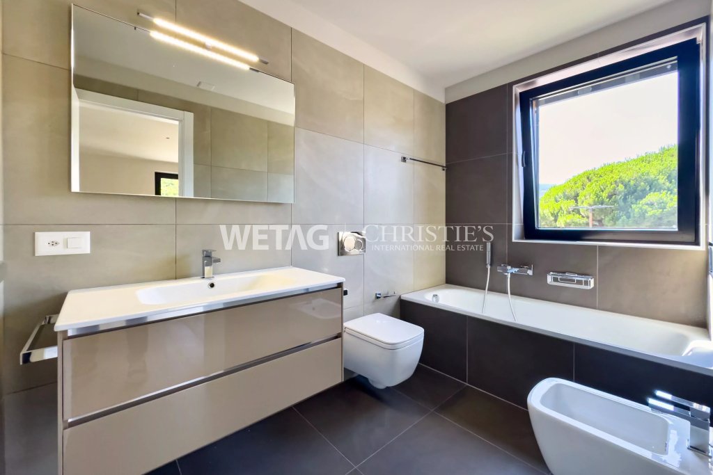 Modernes Badezimmer mit Badewanne und Fensterblick