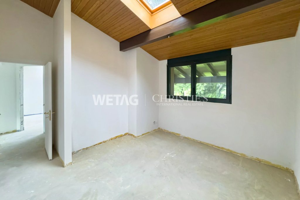 Leerer Raum mit Dachfenster und Holzdecke