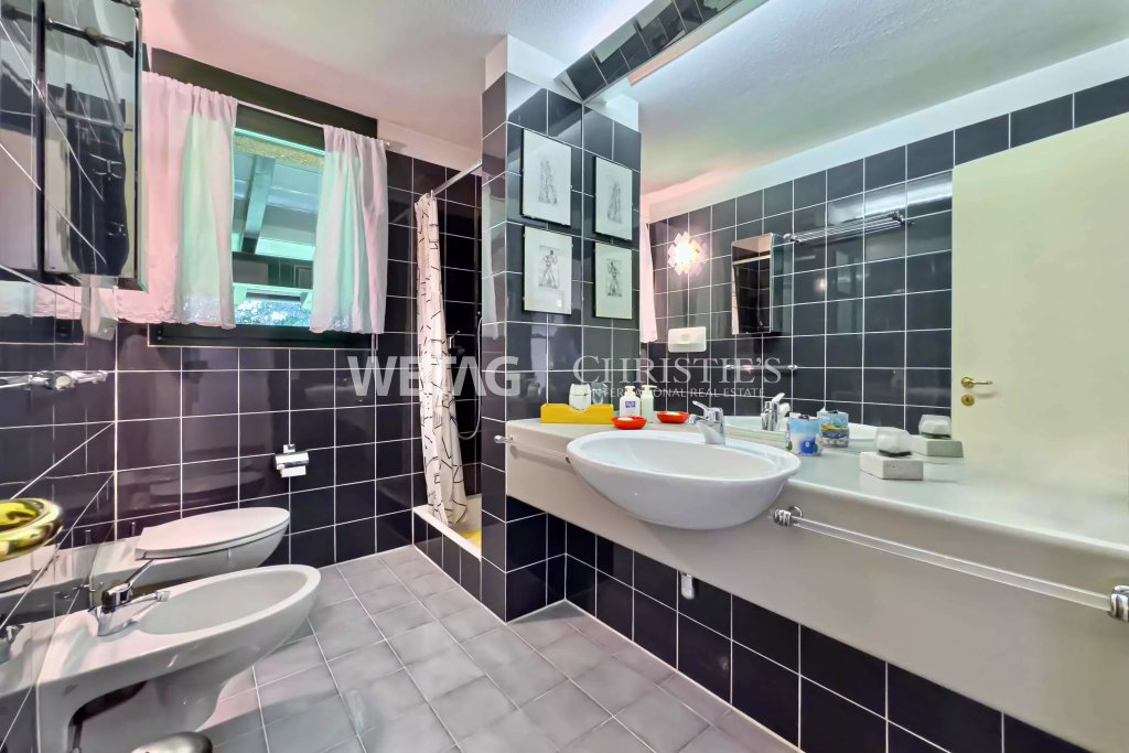 Modernes Badezimmer mit dunklen Fliesen und Doppelwaschtisch