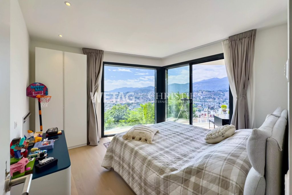 Helles Schlafzimmer mit Panoramafenstern und Bergblick