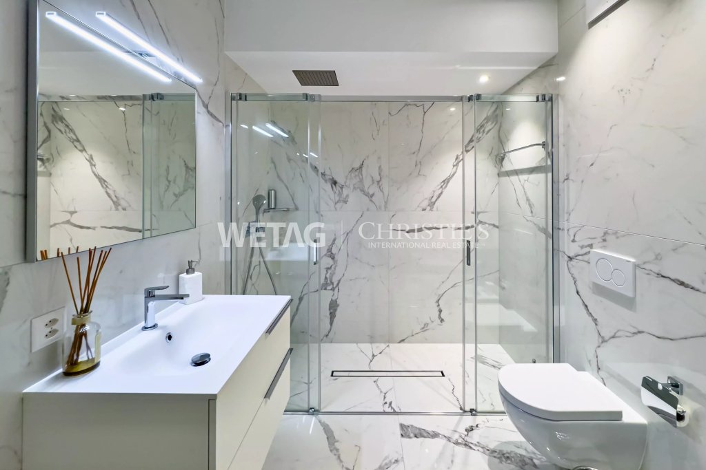 Modernes Badezimmer mit Marmoroptik und Glasdusche