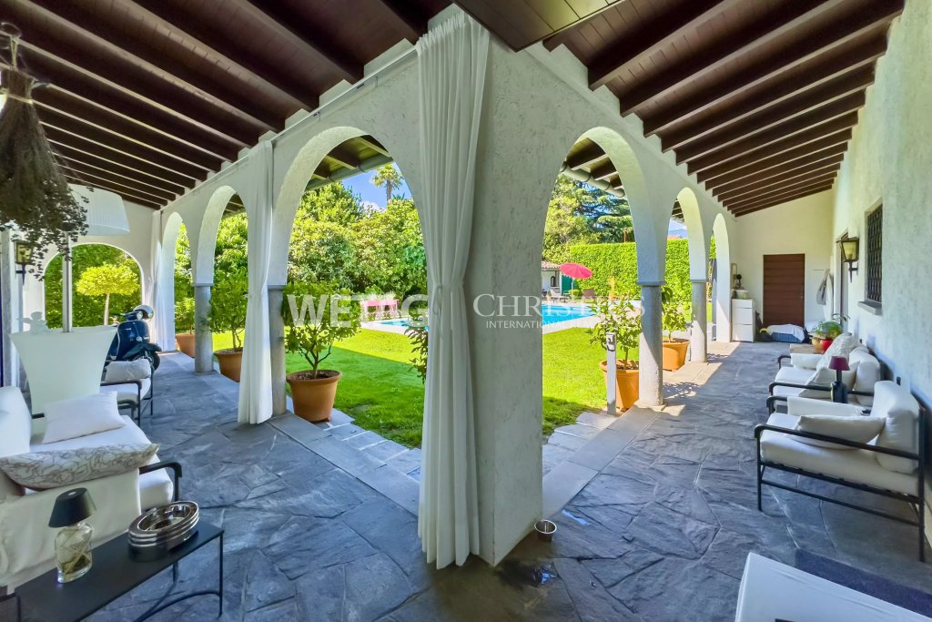 Überdachte mediterrane Terrasse mit Poolblick