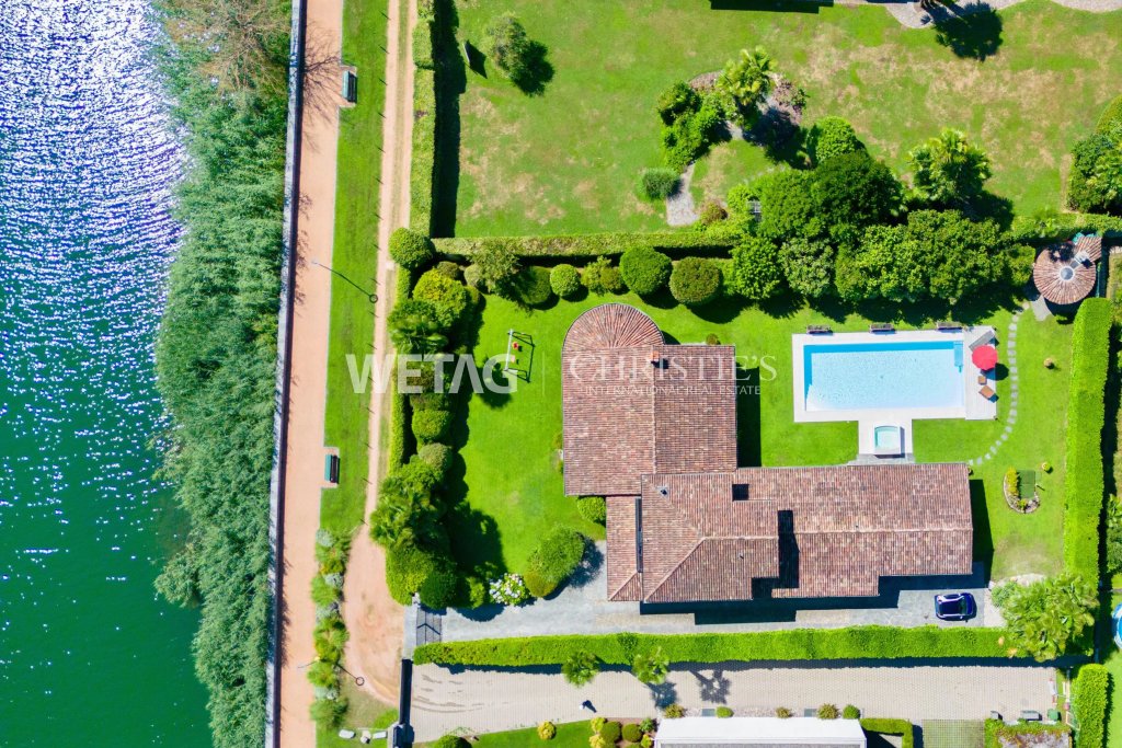 Luftaufnahme eines Grundstücks am Wasser mit Pool und Haus