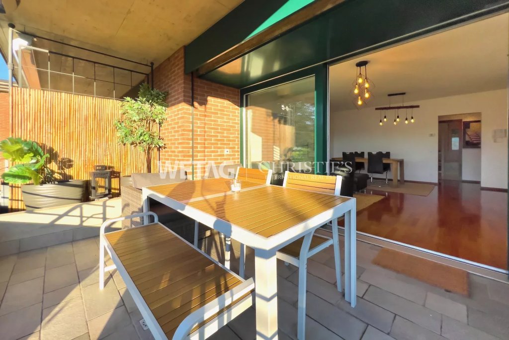 Terrasse mit Essbereich vor großflächiger Schiebetür