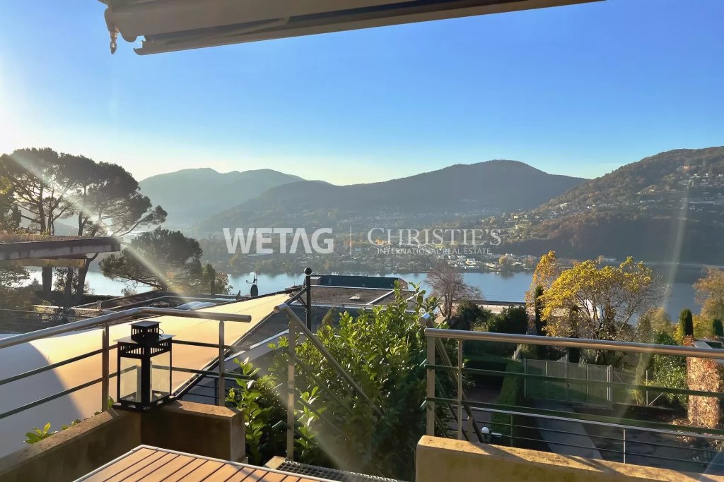 Blick von einer Terrasse auf einen See und Berge