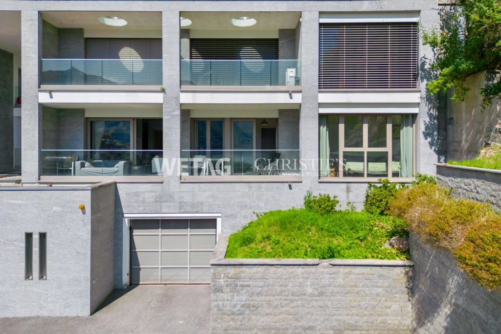 Moderne Außenansicht eines Mehrfamilienhauses mit Terrassen und Garage