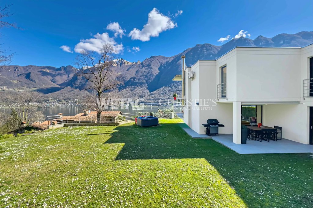 Außenansicht einer modernen Villa mit großem Garten und Seeblick