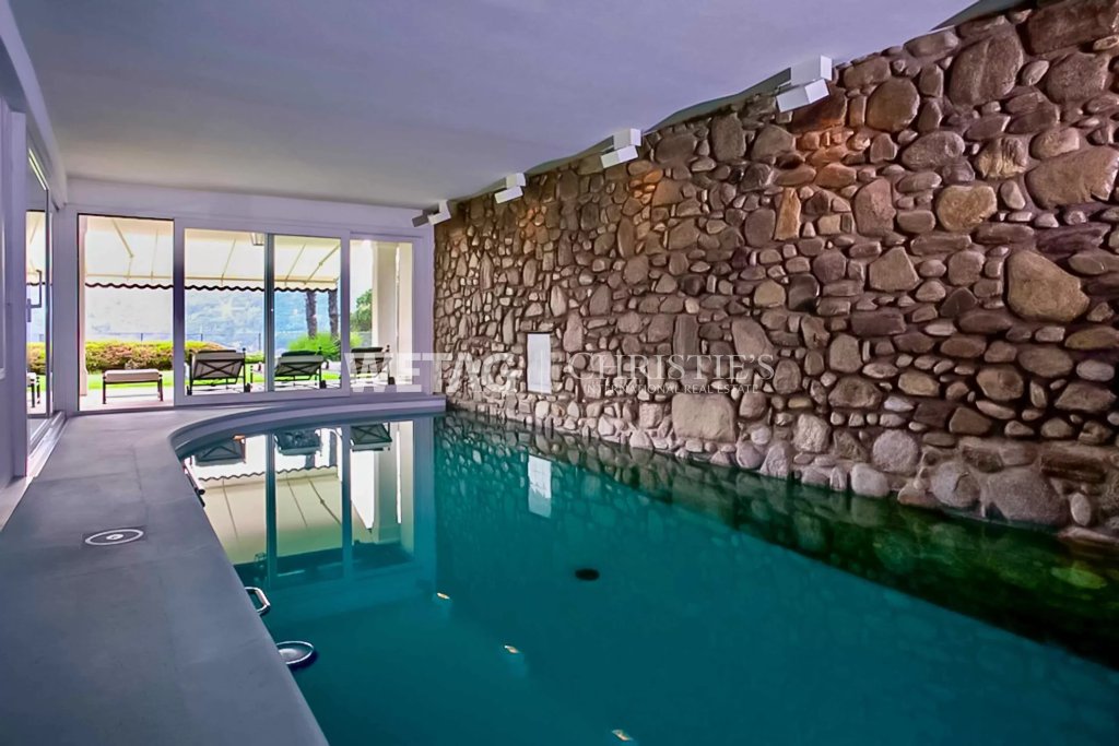 Innenpool mit Natursteinwand und Terrassenblick