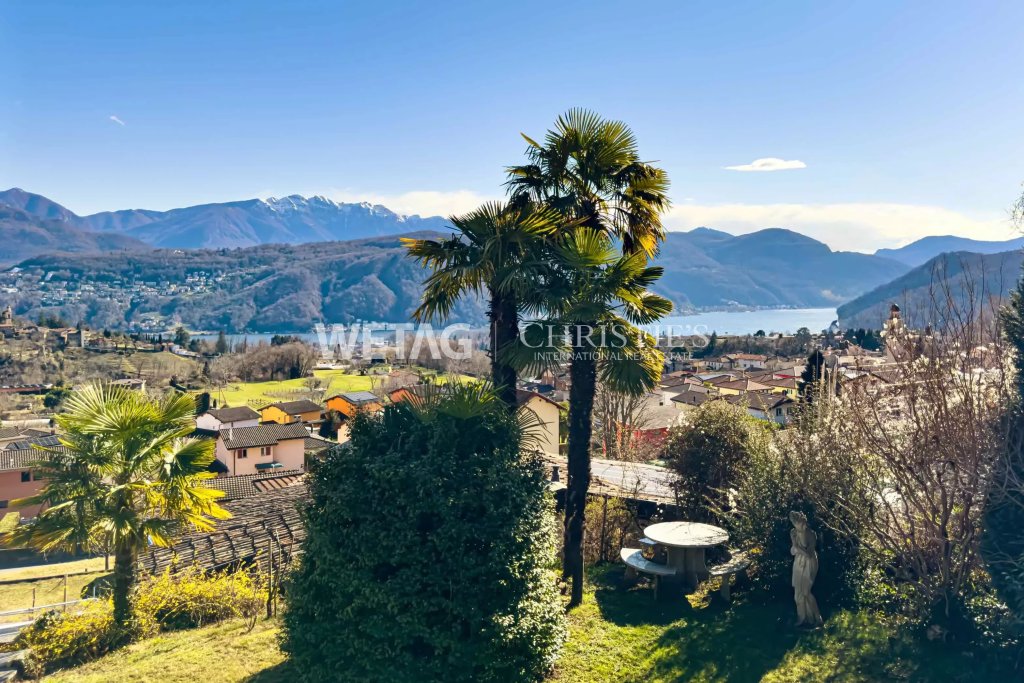 Panoramablick auf See und Berge mit Garten im Vordergrund