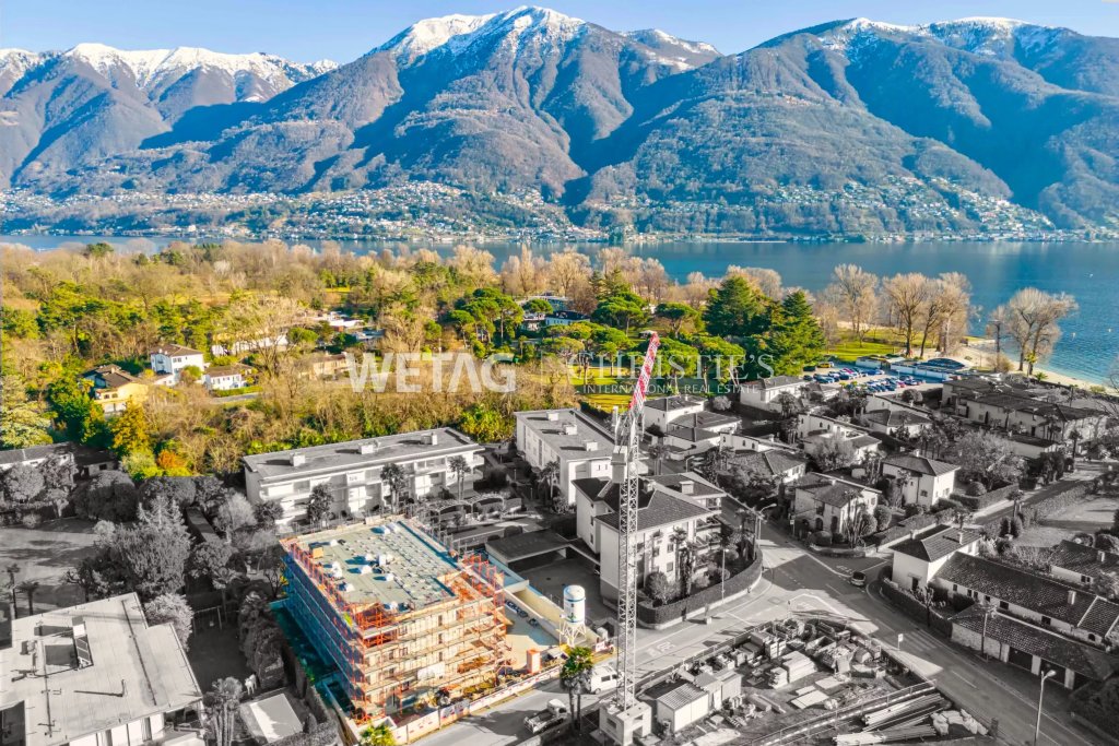 Luftaufnahme eines Seegrundstücks mit Bergen im Hintergrund