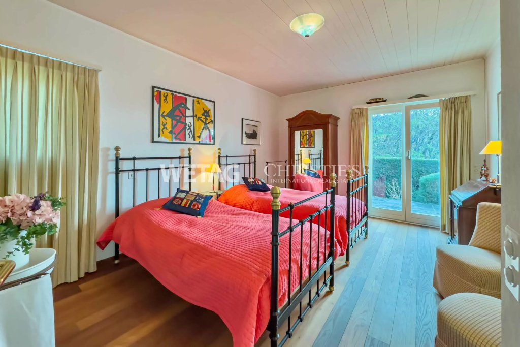 Helles Schlafzimmer mit zwei Betten und Gartenblick