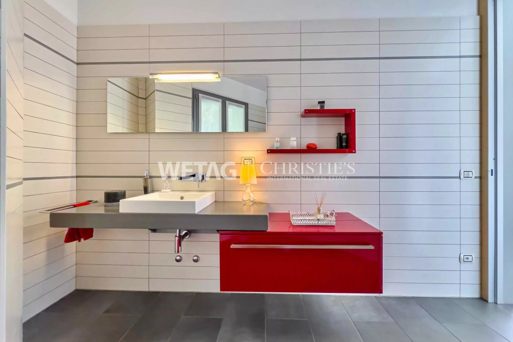 Modernes Badezimmer mit auffälligem roten Waschtisch