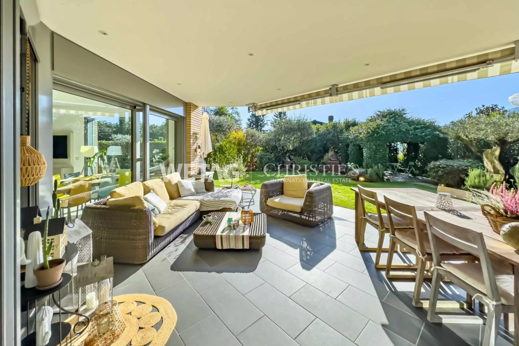 Überdachte Terrasse mit Gartenlounge und Essbereich