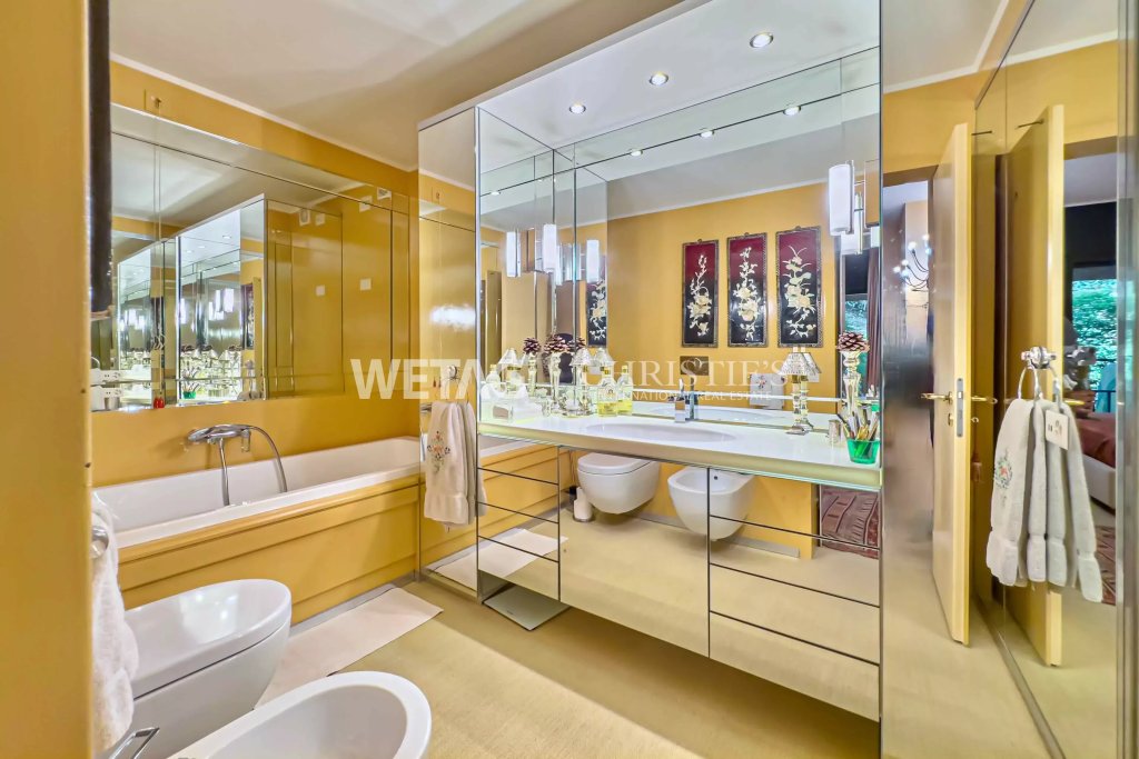Luxuriöses Badezimmer mit goldgelben Wänden und großflächigen Spiegeln