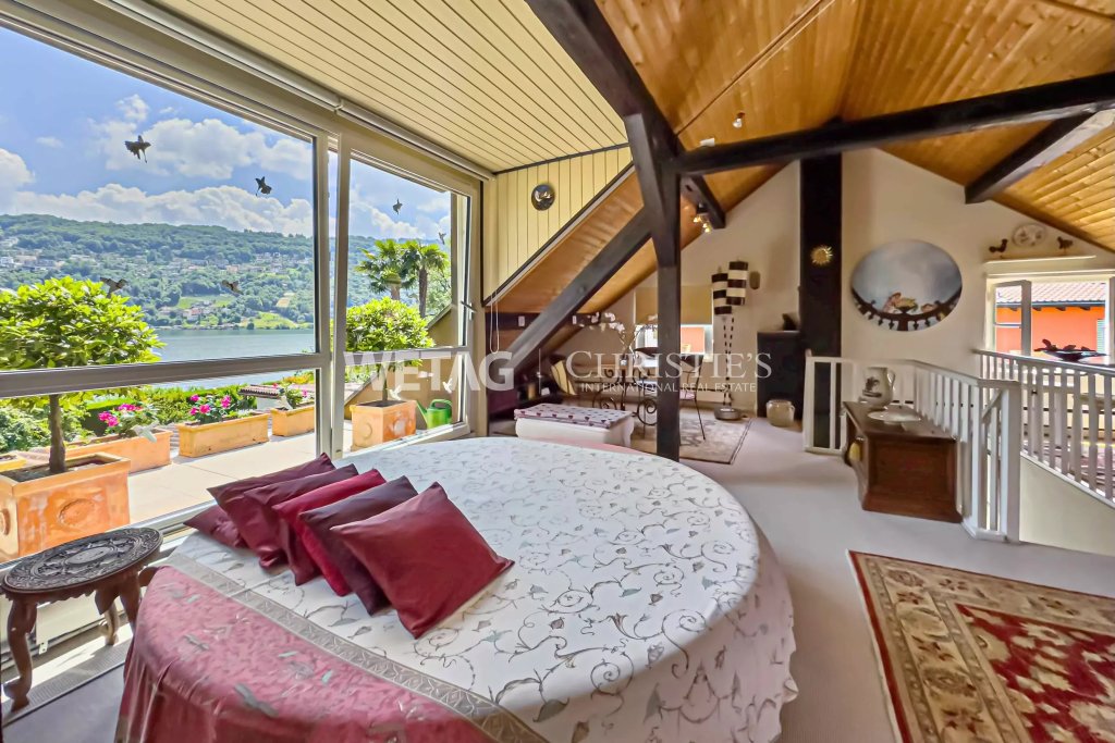 Schlafzimmer mit Panoramafenster und Seeblick
