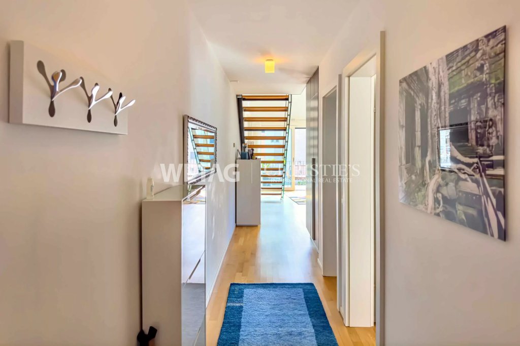 Heller Flur mit Treppe im Hintergrund