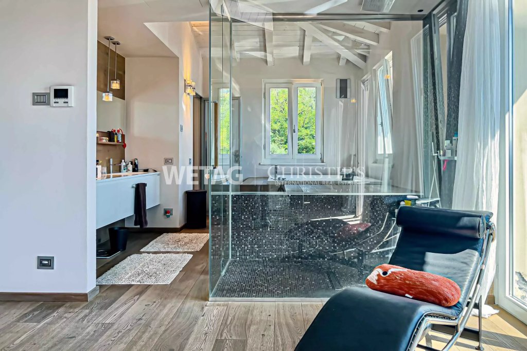 Modernes Badezimmer mit Glasabtrennung und Holzfußboden