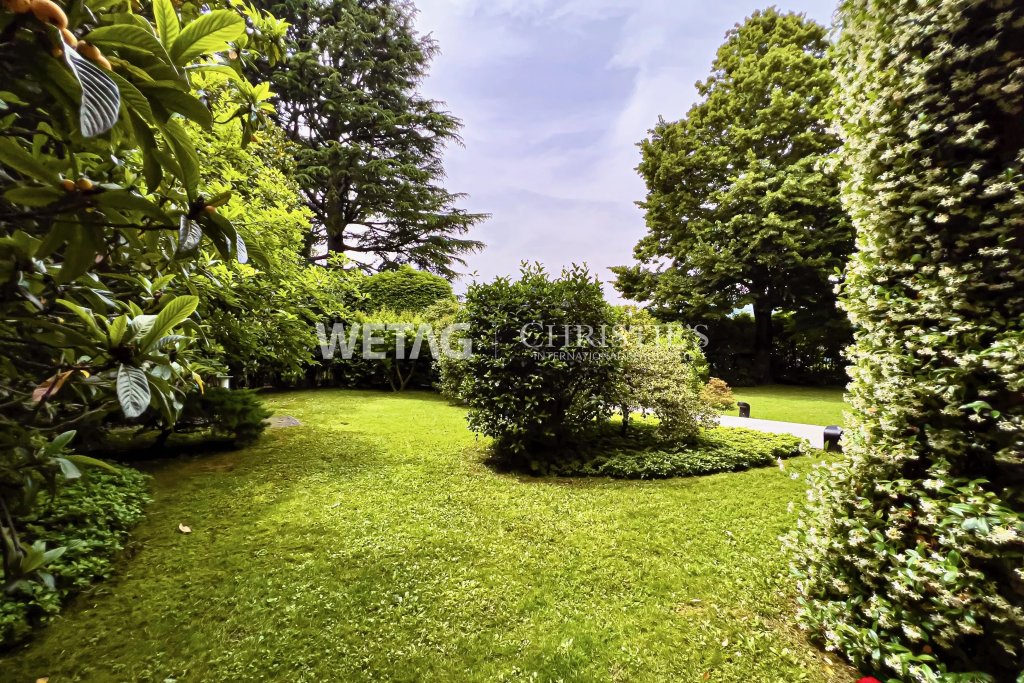 Gepflegter Garten mit Rasen und großen Bäumen