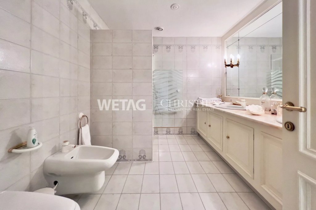 Helles Badezimmer mit Doppelwaschtisch und Glastrennwand