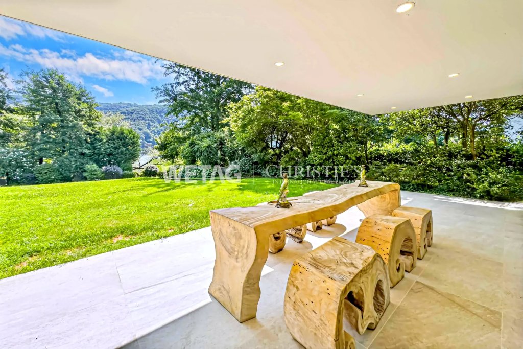 Überdachte Terrasse mit Naturholzmöbeln und Gartenblick