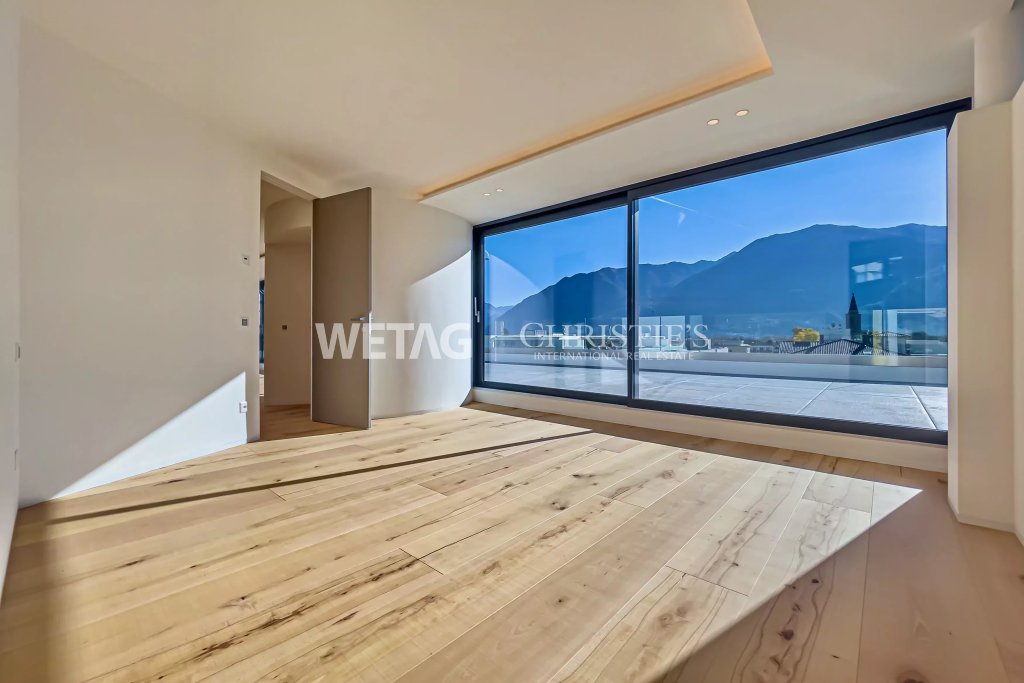 Modernes Schlafzimmer mit Panoramafenster und Bergblick