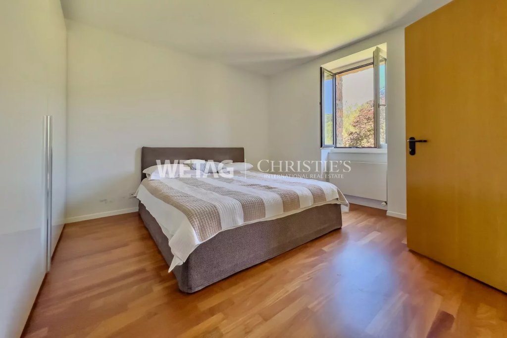 Schlafzimmer mit Holzfußboden und offenem Fenster