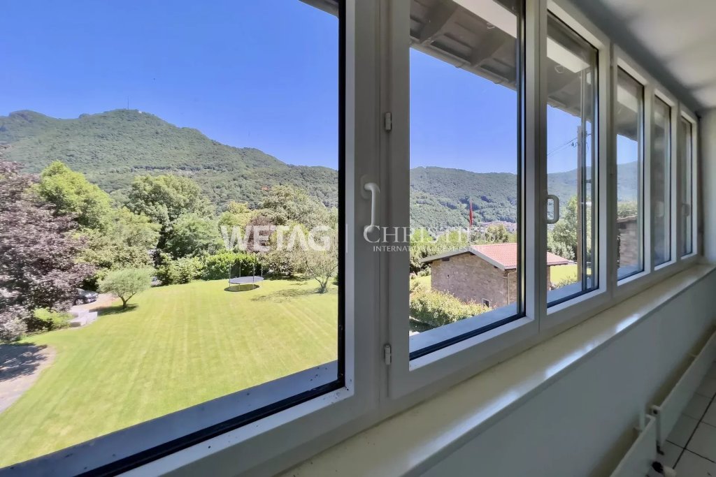 Blick aus einem Flur mit großen Fenstern ins Grüne