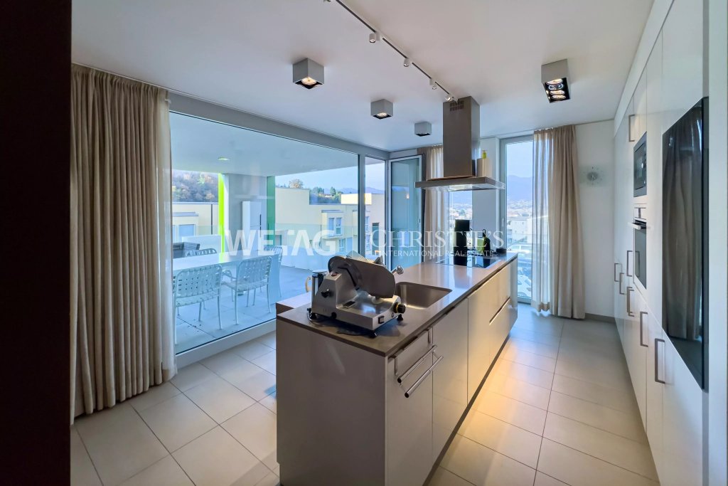 Moderne Küche mit Kochinsel und Zugang zur Terrasse