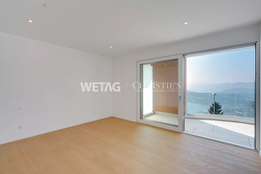 Heller, leerer Wohnraum mit großem Panoramafenster und Balkonblick