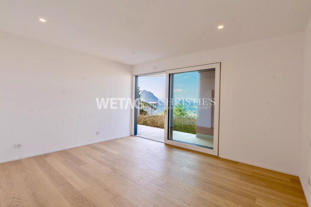 Heller leerer Wohnraum mit Terrassentür und Ausblick