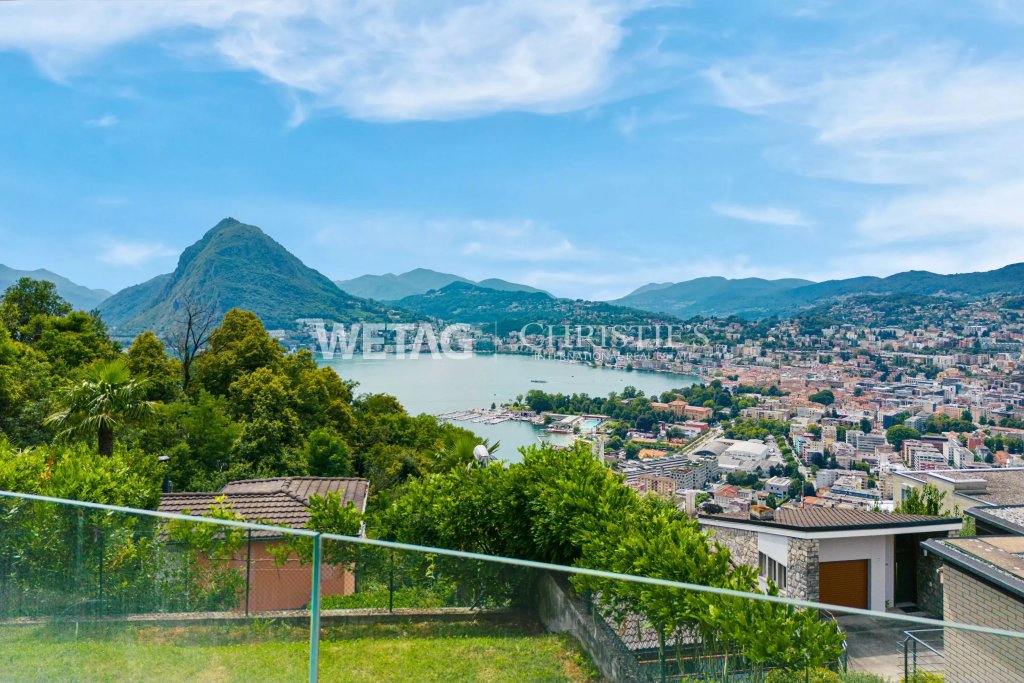 Panoramablick über See und Stadt mit Garten im Vordergrund