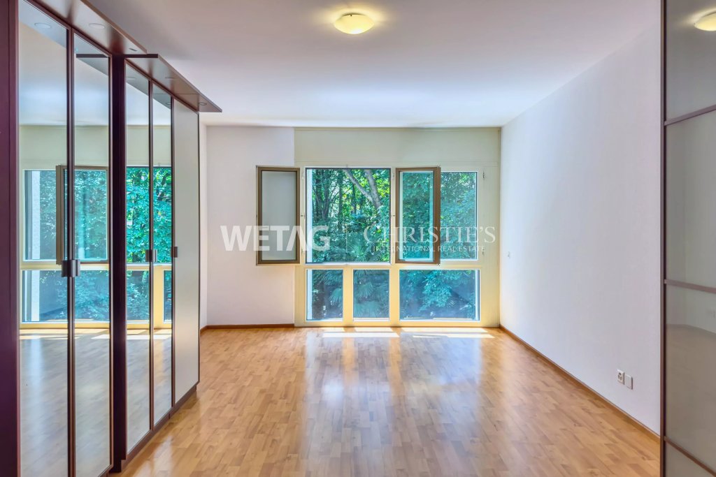 Heller leerer Raum mit Parkett und großem Fenster