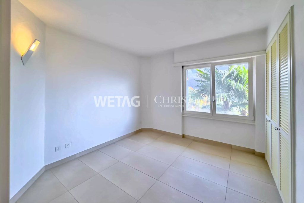 Helles, leeres Schlafzimmer mit Fenster und Einbauschrank