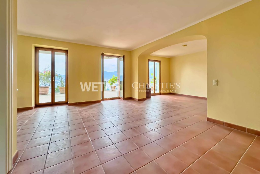 Heller leerer Wohnraum mit Fliesenboden und Blick ins Freie