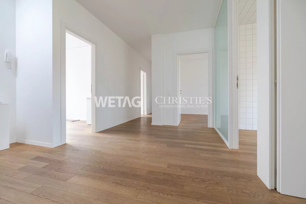 Heller Flur mit Holzfußboden und weißen Türen