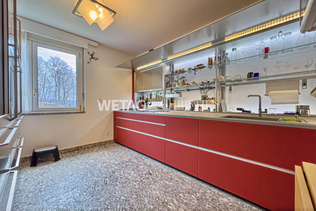 Moderne Küche mit roter Front und Fensterblick