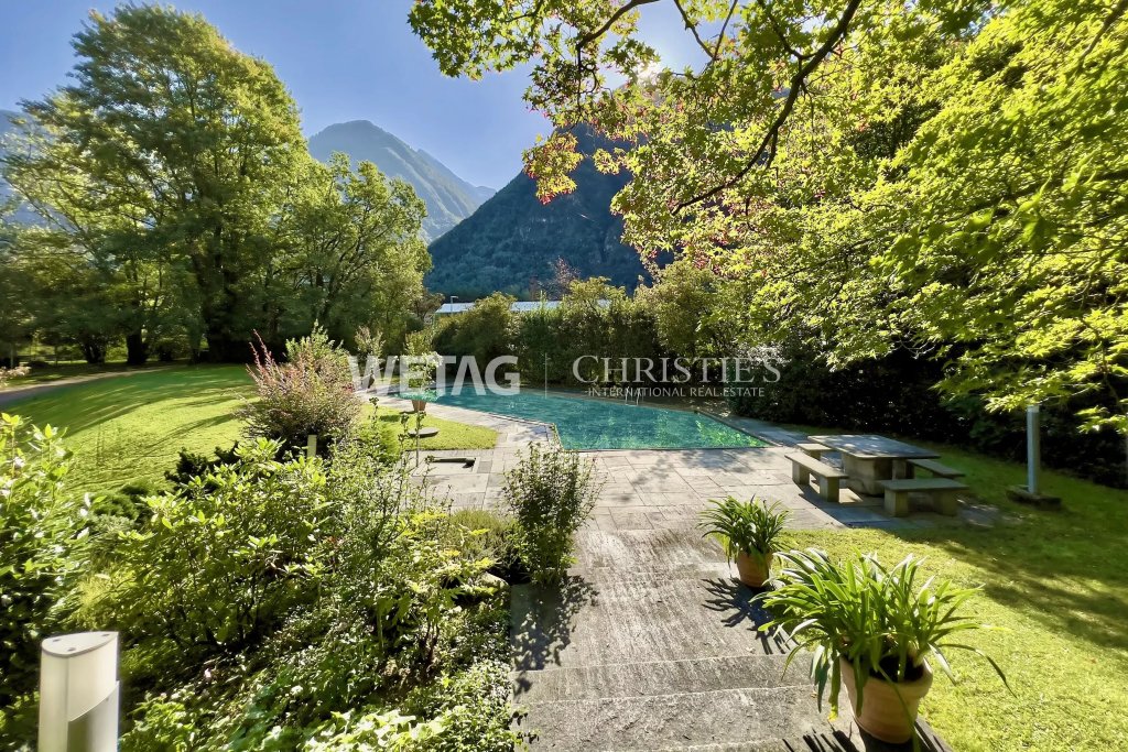 Garten mit Pool vor Bergkulisse