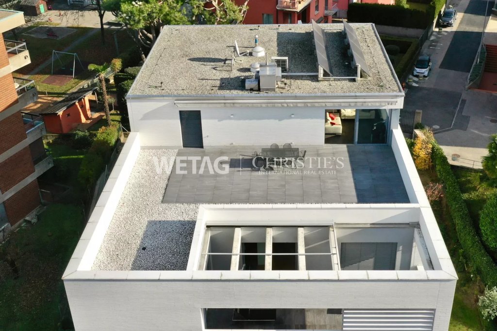 Drohnenaufnahme eines modernen Flachdachhauses mit Dachterrasse
