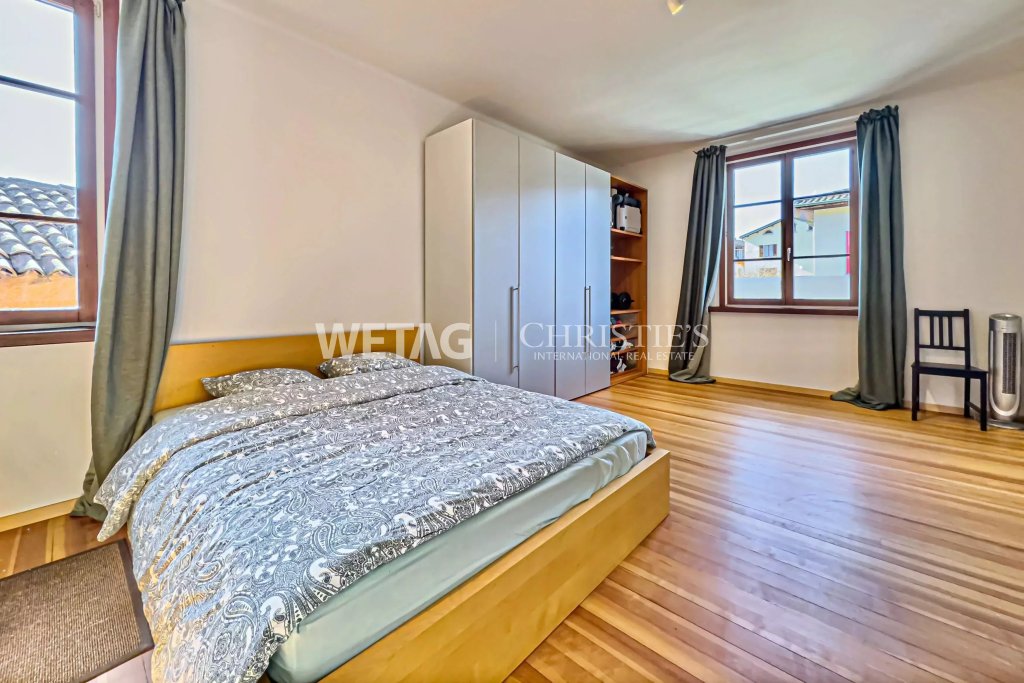 Helles Schlafzimmer mit Holzboden und großen Fenstern