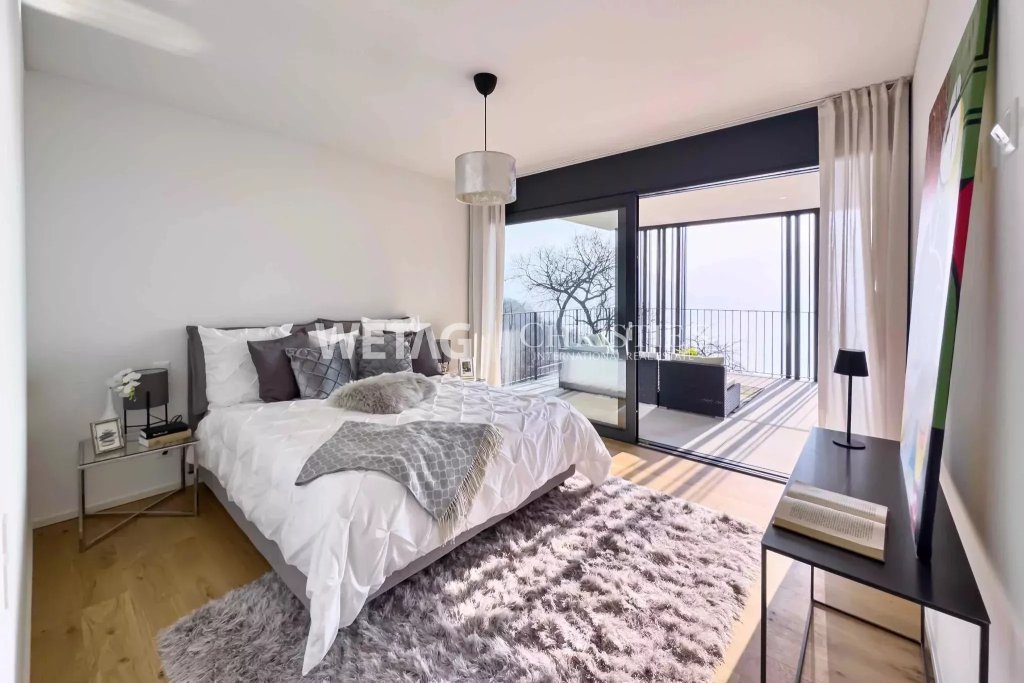 Modernes Schlafzimmer mit großer Glasfront und Terrasse