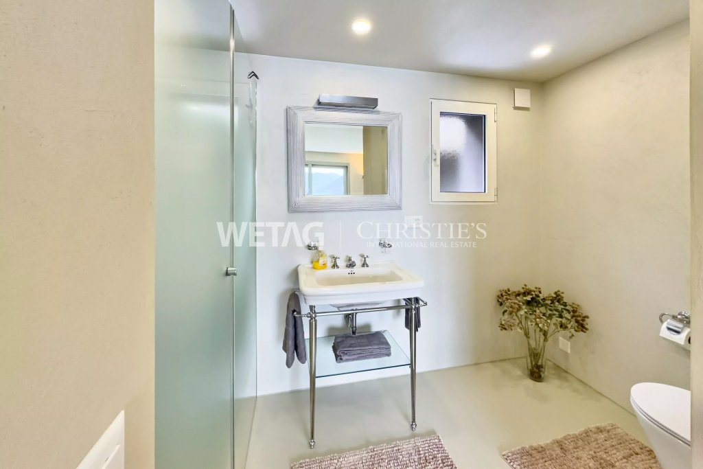 Modernes Badezimmer mit Glastür und Waschplatz