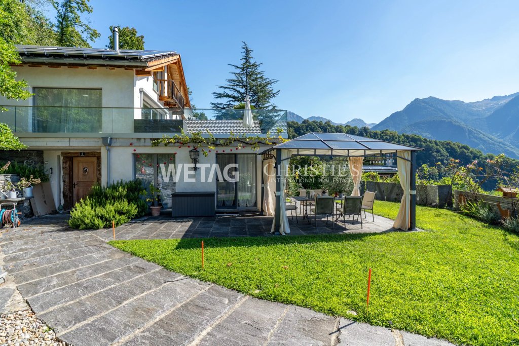 Außenansicht eines Hauses mit Garten und Bergpanorama
