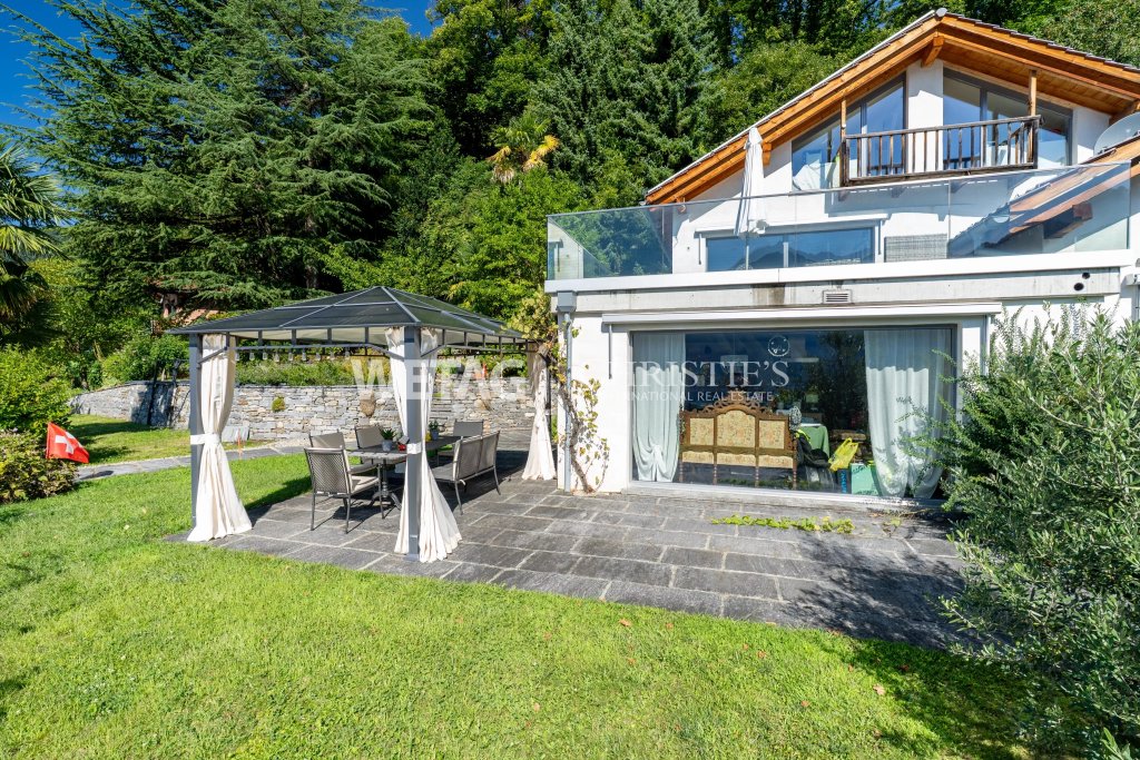 Außenansicht eines modernen Hauses mit Terrasse und Gartenpavillon