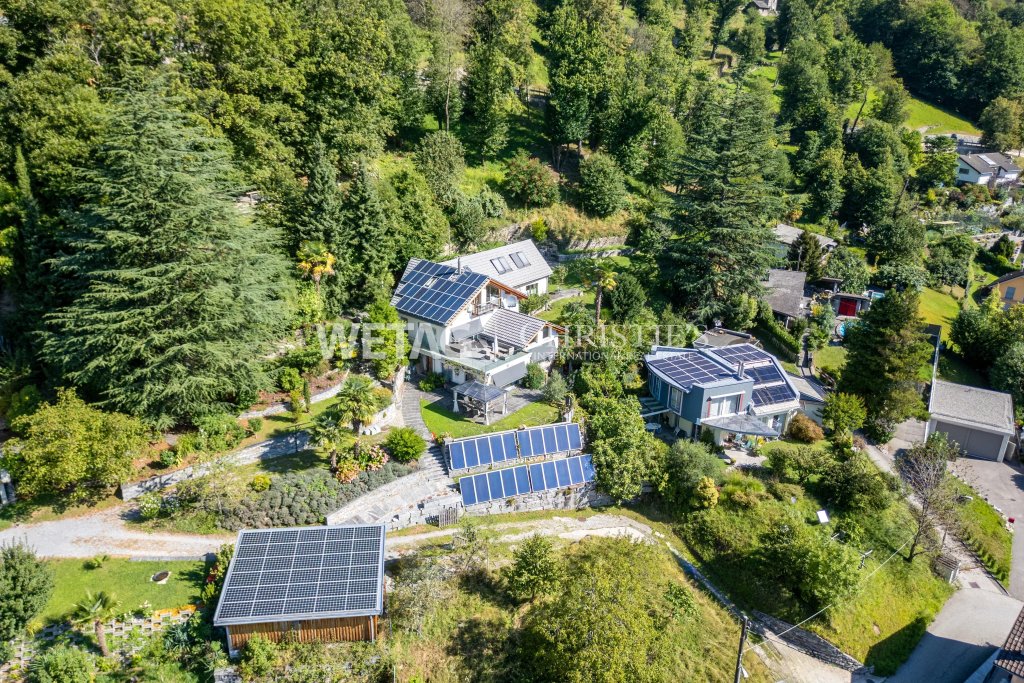 Luftaufnahme eines weitläufigen Grundstücks mit mehreren Gebäuden und Solaranlagen