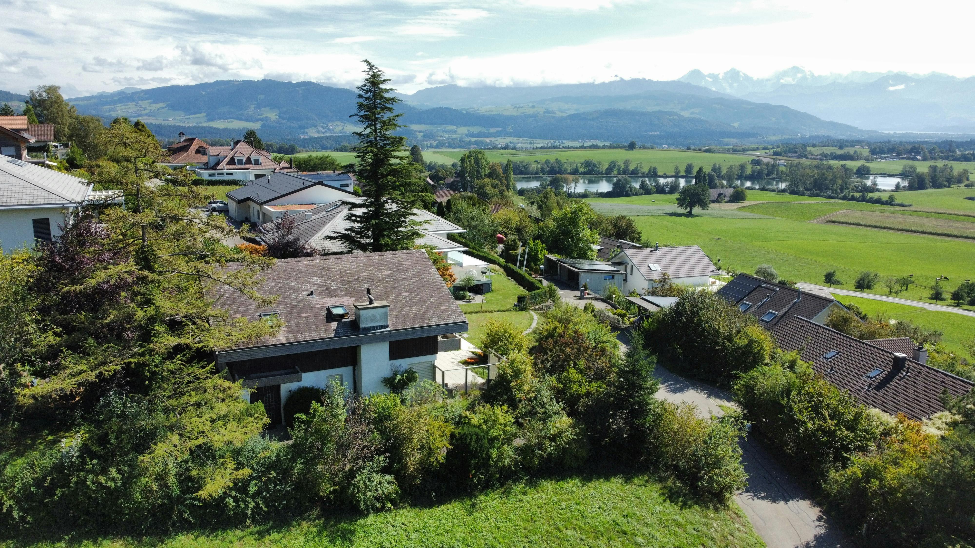 Luftaufnahme einer Wohnsiedlung mit Alpenpanorama