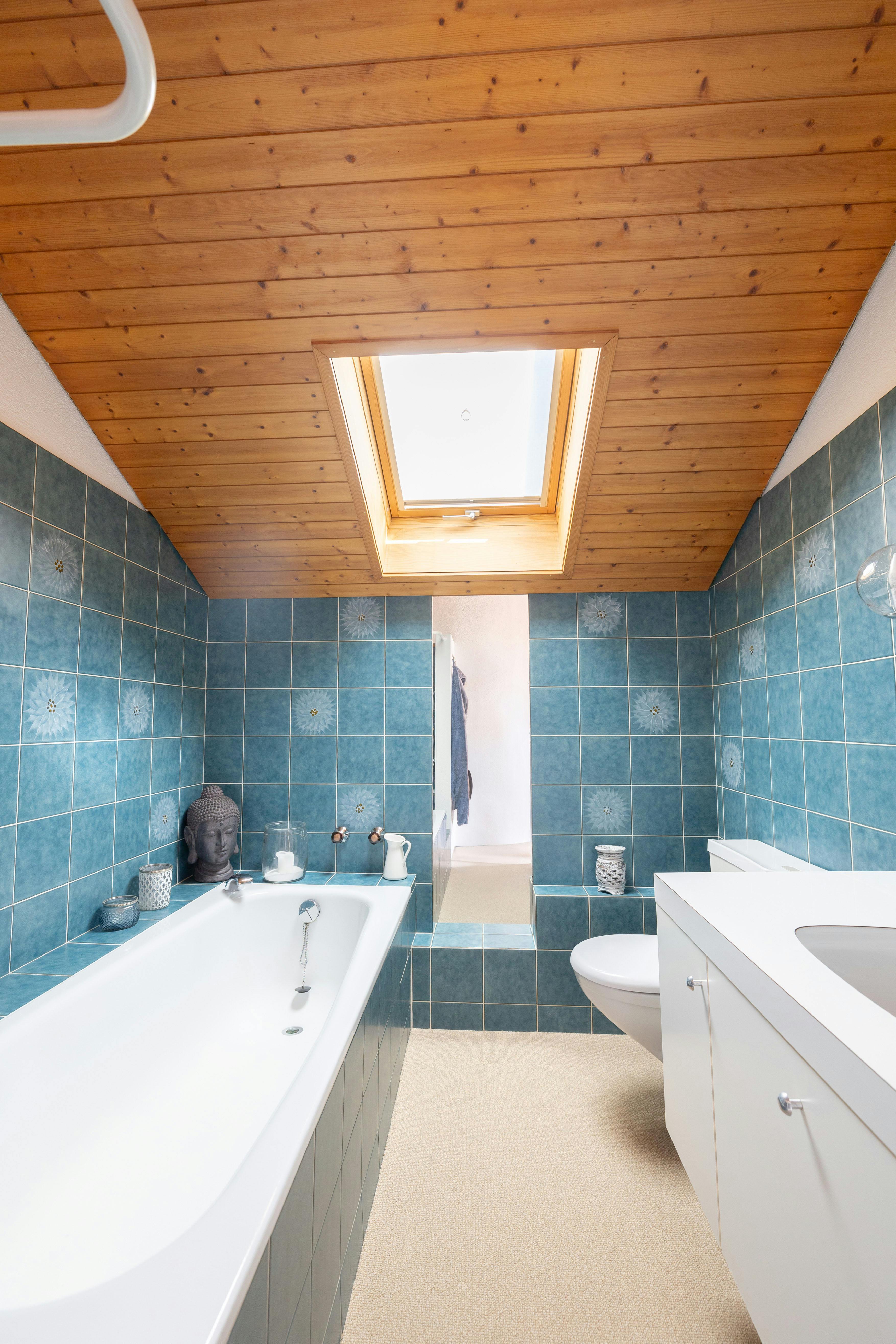 Badezimmer mit Dachfenster und Holzdecke