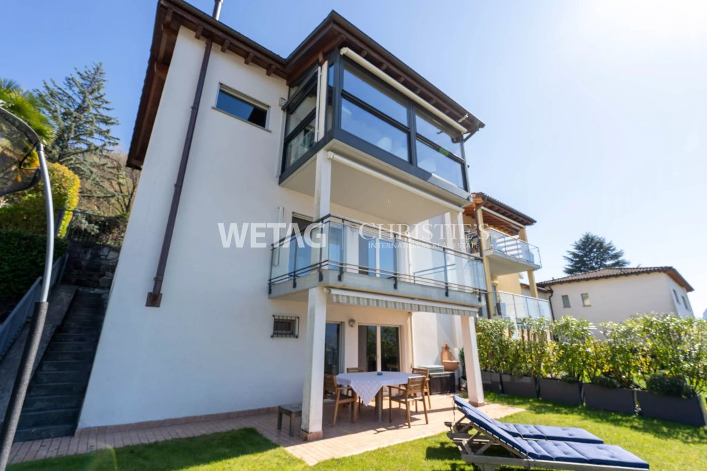 Außenansicht eines mehrgeschossigen Wohnhauses mit Terrasse und Balkon